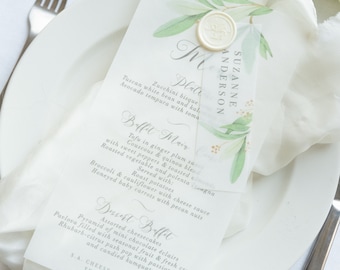 Może przedstawiać: Biała karta menu ślubnego z zielonymi liśćmi akwarelowymi i pieczęcią woskową. Menu zawiera wegetariański posiłek z tofu, kuskus, quinoa i pieczonymi warzywami. Menu deserów zawiera różne serniki, mini eklerki czekoladowe i pawłowę.