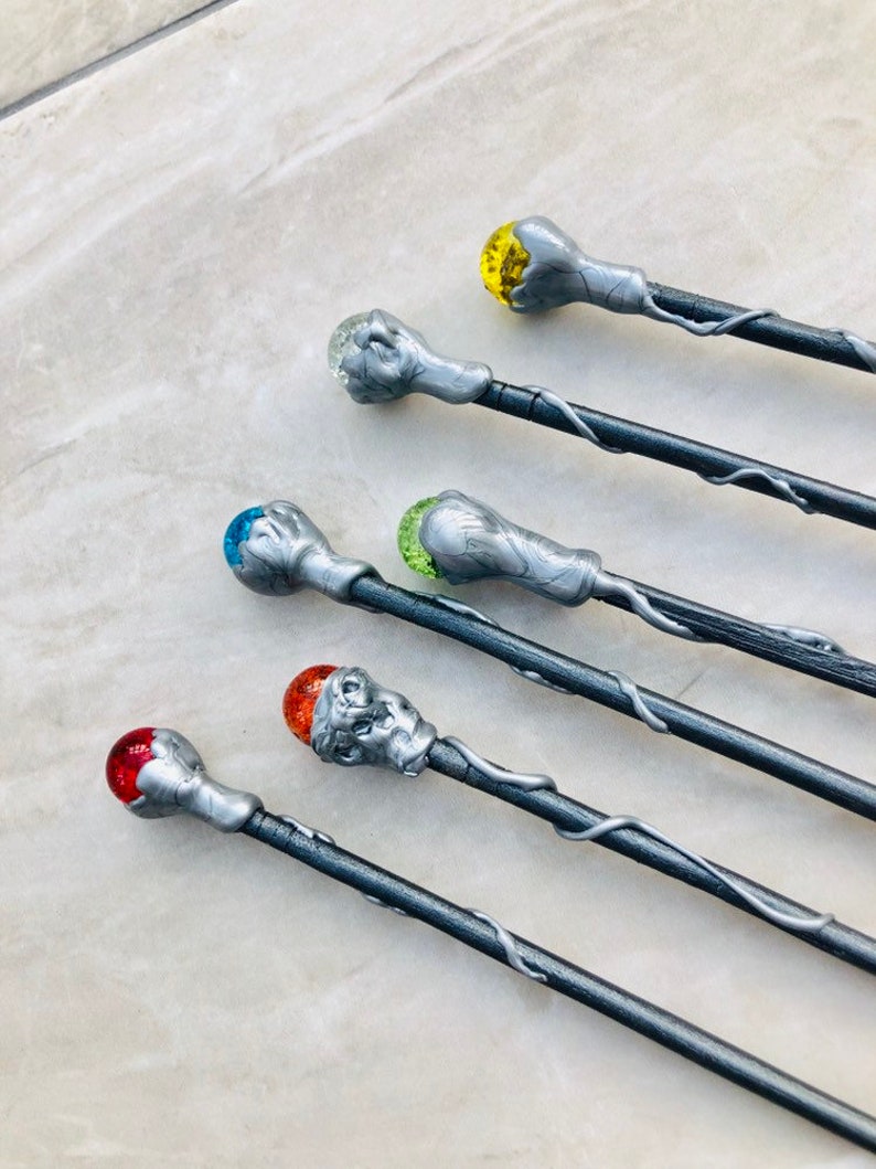 May include: Six silver wands with different colored glass orbs on the ends. The orbs are red, orange, yellow, green, blue, and clear.