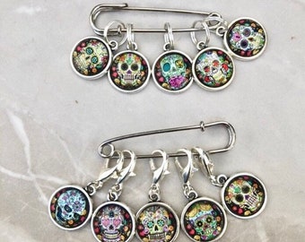 May include: Set of 10 colourful sugar skull stitch markers for knitting or crocheting. The markers are round with silver metal rings and a safety pin.