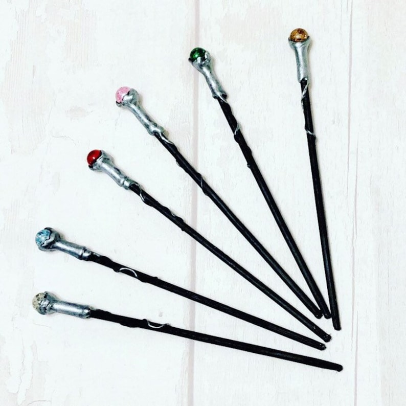 May include: Six black wands with silver tips and colorful gemstone accents. The gemstones are green, pink, red, blue, gold, and a light brown color.