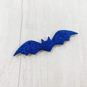 May include: A blue glitter bat cutout. The bat is a popular Halloween decoration.
