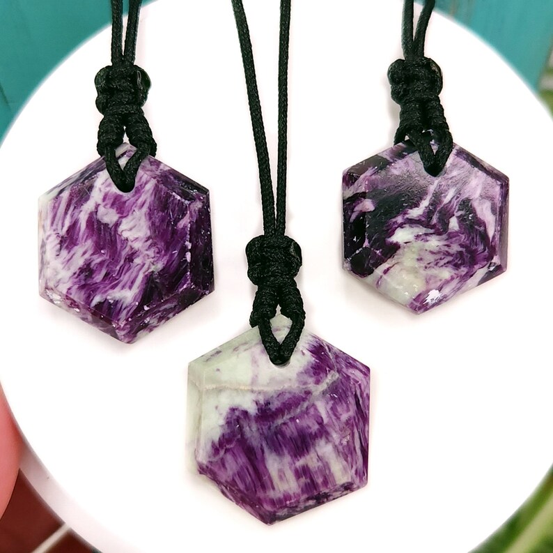 Purple, green, and cream Kammererite hexagon shaped necklaces with adjustable black nylon cords, shown against a white background.