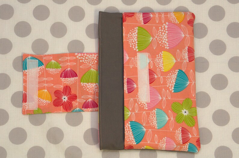 Puede incluir: Dos bolsas de tela con un patr&oacute;n floral en tonos de rosa, verde, azul y amarillo. Las bolsas tienen un borde gris y un cierre de velcro blanco.
