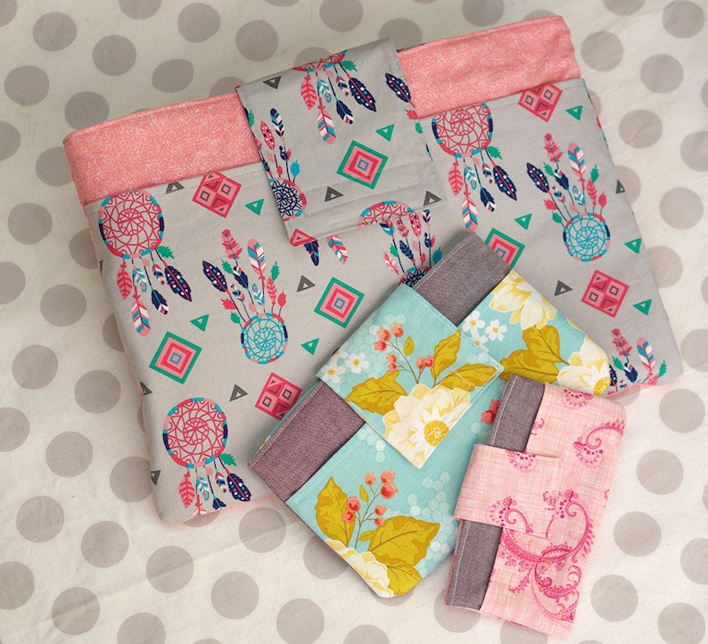 Puede incluir: Cuatro bolsas de tela con diferentes patrones. La bolsa m&aacute;s grande es gris con ribete rosa y presenta un dise&ntilde;o de atrapasue&ntilde;os. Las otras bolsas son m&aacute;s peque&ntilde;as y presentan patrones florales y paisley.