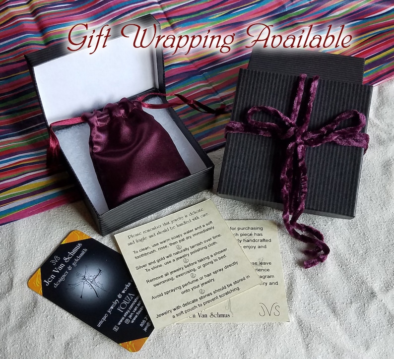 gift wrapping for Etsy shop Fouza showing small decorative pouch within cotton lined black striped box, maroon velvet ties, and colorful stripped tissue paper