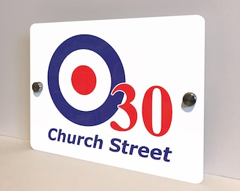 May include: White rectangular sign with a blue and red target design, the number 30 in red, and the words "Church Street" in blue. The sign is mounted with two silver-colored screws.