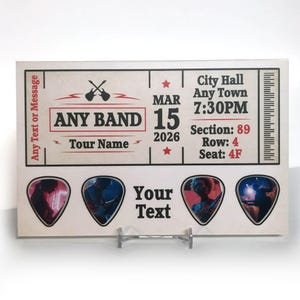 Könnte beinhalten: Ein personalisiertes Konzertticket-Design mit dem Text "ANY BAND" und Platz für "Your Text". Das Ticket zeigt das Datum "15. MÄRZ 2026" und Veranstaltungsortinformationen. Vier gitarrenförmige Bereiche sind zur Personalisierung verfügbar.