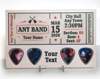May include: A custom concert ticket design with the text "ANY BAND" and "Your Text". The ticket includes the date "MAR 15 2026" and venue details. Four guitar pick-shaped spaces are available for personalization.