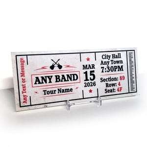 Könnte beinhalten: Ein Konzertticket im Vintage-Design. Das Ticket zeigt "ANY BAND" und "Tour Name" in Rot und Schwarz. Das Datum ist der 15. März 2026 um 19:30 Uhr im Rathaus, Any Town. Das Ticket enthält auch Informationen zu Sektion, Reihe und Sitz.