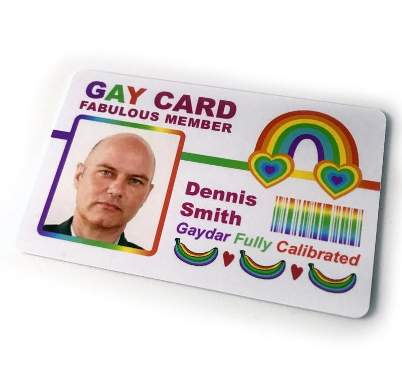 May include: A white card with the text "Gay Card Fabulous Member" at the top. The card features a rainbow, hearts, and bananas. The text "Dennis Smith Gaydar Fully Calibrated" is printed below the rainbow.
