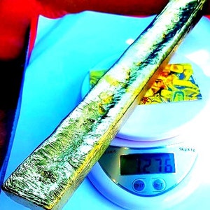 May include: A silver bar on a digital scale, the scale reads 127.8 grams.