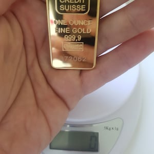 May include: A gold bar with the inscription "CREDIT SUISSE ONE OUNCE FINE GOLD 999.9" and the number "372062".