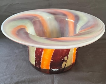 May include: A colorful glass vase with a wide, swirling top and a cylindrical base. The vase is decorated with stripes of orange, red, white, and gray. The base of the vase has the text "Bosa Bosa" in black.