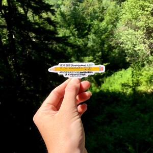 May include: A yellow pencil sticker with the quote "IT IS THE Supreme ART OF THE Leccinek TO AWAKEN NJOY in CREATIVE expreffion & KNOWLEDGE." The quote is attributed to "ALBERT EINSTEIN".
