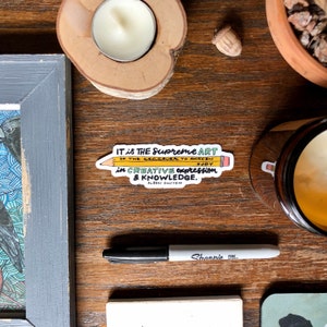 May include: A yellow pencil sticker with a quote by Albert Einstein: "IT is THE Supreme ART OF THE teacher TO AWAKEN #JOY in CREATIVE expression & KNOWLEDGE."
