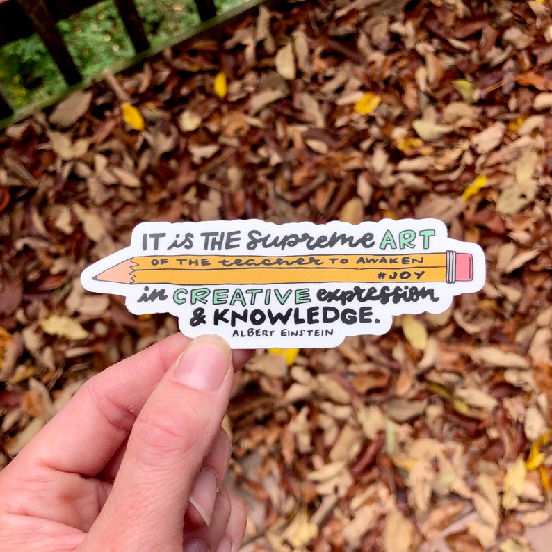 May include: A white sticker with a yellow pencil and text that reads "IT is THE Supreme ART OF THE teacher TO AWAKEN #JOY in CREATIVE expression & KNOWLEDGE. ALBERT EINSTEIN"