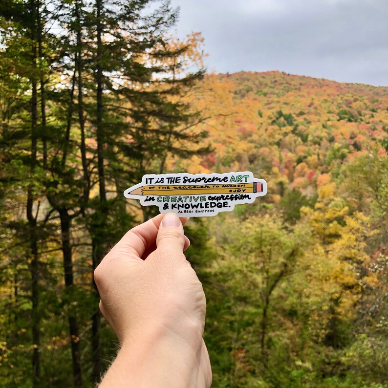 May include: A yellow pencil sticker with a quote by Albert Einstein: "IT is THE Supreme ART OF THE Teacher TO AWAKEN JOY in CREATIVE expression & KNOWLEDGE."