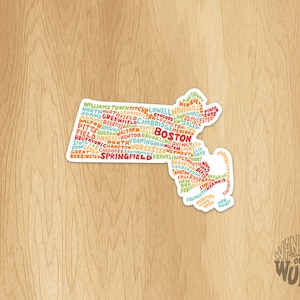 May include: A sticker of the state of Massachusetts with the names of cities and towns in the state written in a word cloud. The sticker is white with a rounded edge and has the text "WANDER ON WORDS" at the bottom.