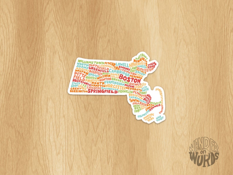 May include: A sticker of the state of Massachusetts with the names of cities and towns in the state written in a word cloud. The sticker is white with a rounded edge and has the text "WANDER ON WORDS" at the bottom.