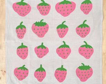 Puede incluir: Una toalla de cocina blanca con un patrón repetido de fresas rosas con hojas verdes. Las fresas son estilizadas y tienen un diseño simple.