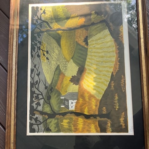 May include: A framed print of a landscape with a small house in the center. The landscape is made up of abstract shapes in shades of green, yellow, and brown. The print is signed in the bottom right corner.