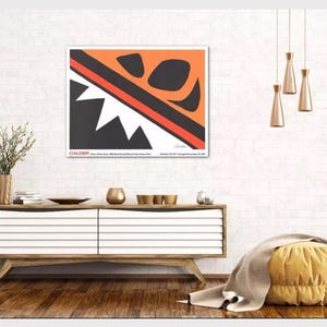 May include: A black and white abstract art print with orange and red accents. The print features geometric shapes and is titled "CALDER" with the artist's signature.