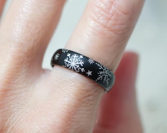 Anillo de nieve: diseño de copos de nieve blancos sobre una banda de tungsteno negro de ajuste cómodo. Incluye grabado personalizado opcional en el interior.