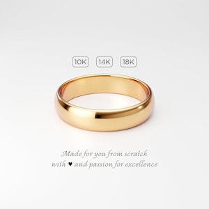 A 5mm wide solid gold wedding band for men, handmade to order in 10k, 14k, or 18k yellow gold. Simple plain classic dome ring with smooth polished finish. The ring is shown on a very light gray background with the text "Made for you from scratch with love and passion for excellence."