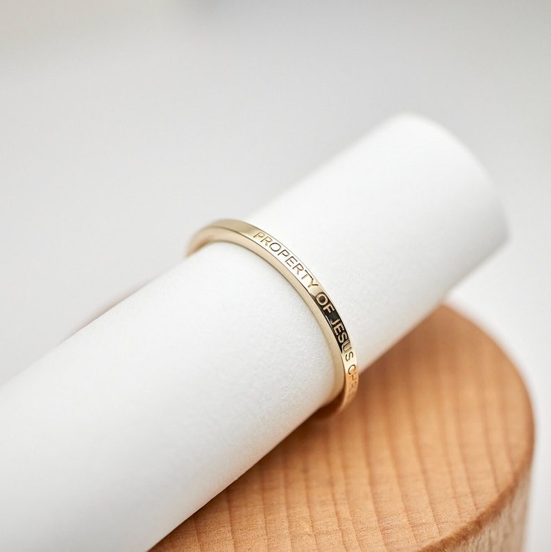 May include: A gold ring with the inscription "PROPERTY OF JESUS CHRIST" engraved on the band.