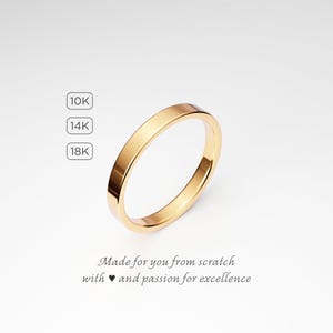 May include: A gold-colored ring with a flat band. The image includes text indicating 10K, 14K, and 18K gold options. The ring is displayed on a white background. Text at the bottom reads "Made for you from scratch with and passion for excellence."