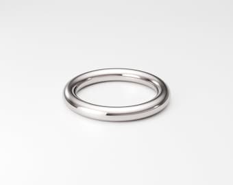 May include: A polished silver-toned metal ring with a smooth, rounded band. The circular band features a reflective, high-gloss finish that catches the light, creating a clean and simple appearance with no additional stones or engravings.
