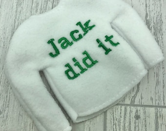 May include: White elf-sized sweater with long sleeves and green embroidered text that reads "Jack did it".