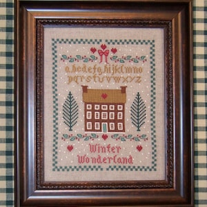 以下が含まれることがあります： 家、木、そして「Winter Wonderland」の文字が描かれた額入りのクロスステッチアート。 アートワークにはアルファベット、ハート、装飾的なボーダーが含まれています。 フレームは濃い茶色です。