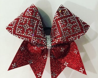 May include: A red glitter cheer bow with silver rhinestones and a silver bow center.