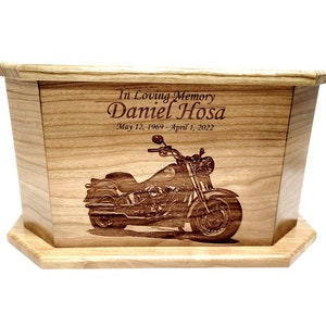 May include: Wooden cremation urn with an engraved image of a motorcycle and the text "In Loving Memory Daniel Hosa May 12, 1969 - April 1, 2022"