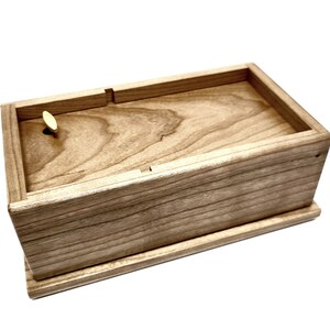 a small wooden box with a single piece of wood in it