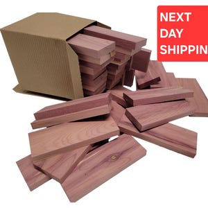 May include: A cardboard box overflowing with rectangular cedar wood planks. The planks are various sizes and shades of reddish-brown. The image includes a red rectangle with the words "NEXT DAY SHIPPING".