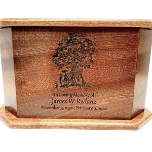 May include: A wooden cremation urn with a tree of life design engraved on the front. The urn is inscribed with "In Loving Memory of James W. Redanz November 3, 1952 - February 9, 2020".