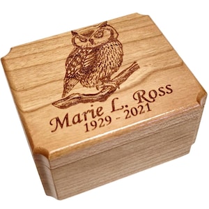 Könnte beinhalten: Eine Holzkiste mit einer gravierten Eule und dem Text "Marie L. Ross 1929 - 2021".