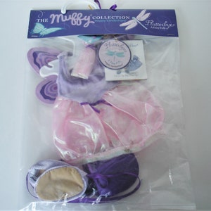 May include: A children's butterfly costume set in a clear plastic bag. The set includes a purple and pink dress, matching wings, and shoes. The packaging features the text "The Muffy Collection" and "Flutterbyes".