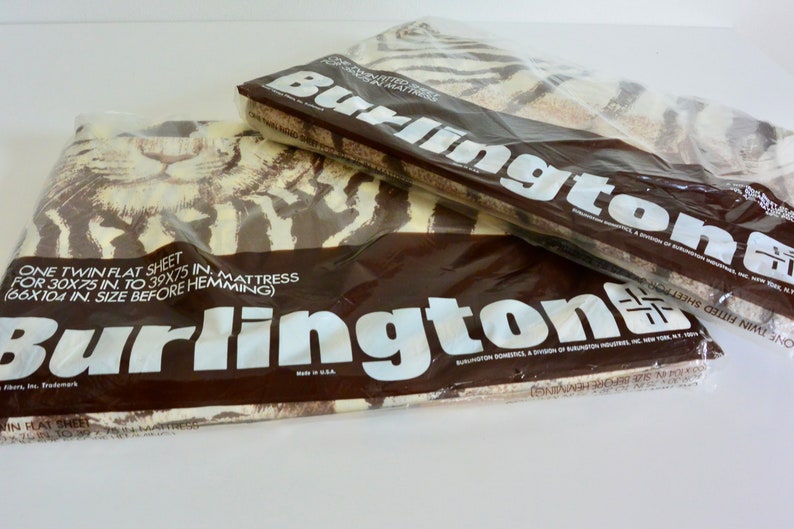 May include: Two packages of Burlington twin flat sheets in plastic packaging. The sheets feature a brown and white zebra print. The packaging includes the text "One twin flat sheet for 30x75 in. to 39x75 in. mattress (66x104 in. size before hemming)" and "Burlington Domestics, a division of Burlington Industries, Inc., New York, N.Y. 10001."