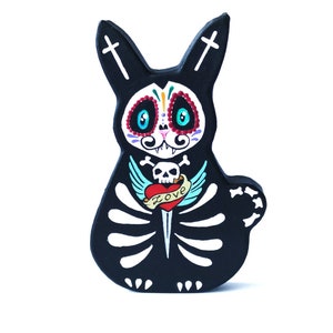 Le lapin crâne de sucre noir est fait de papier mâché peint à la main le jour des morts de style mexicain