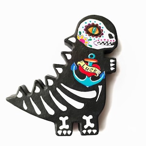 Le dinosaure de crâne de sucre noir est fait de papier mâché peint à la main le jour du style mexicain mort