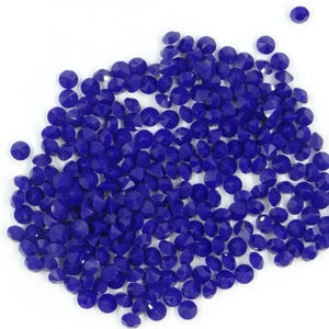 Peut inclure: Un grand tas de petites perles de verre rondes bleues. Les perles sont facettées et ont une finition brillante.