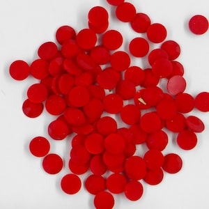 May include: A pile of small, round, red glass rhinestones.