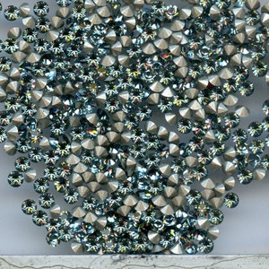 Peut inclure: Gros plan sur une grande quantité de petits strass facetés de couleur argentée avec une finition bleu irisée.