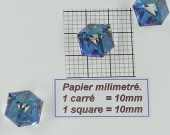 May include: Three blue faceted glass beads on a white background with a gridded ruler and a note that reads "Papier millimétré. 1 carré = 10mm. 1 square = 10mm".