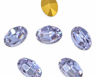 May include: A collection of six oval-shaped faceted crystals arranged in a circular pattern. Five of the crystals are clear with light purple undertones and reflective surfaces, while one crystal at the top is solid matte gold in color.