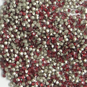 Peut inclure: Gros plan sur une grande quantité de petits strass plats. Les strass sont un mélange d'argent et de rouge.
