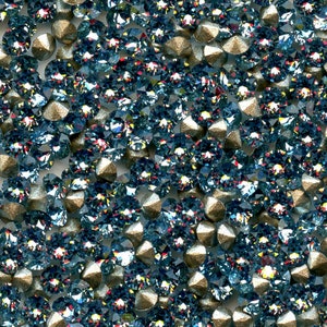 Peut inclure: Gros plan sur une grande quantité de petits strass ronds bleus irisés avec une finition argentée métallisée. Les strass sont dispersés de manière aléatoire et semblent être lâches.